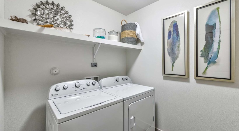 large laundry room with ample lighting and built-in shelf